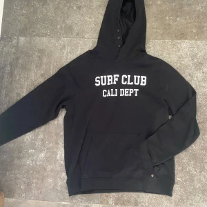 Mörkblå hoodie - Mörkblå hoodie från Dobber med knappar på luvan. Väldigt clean är är helt ny med tag på. Ny pris: 600kr mitt pris: 350kr