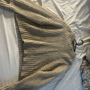 en stickad tröja  - den har blivit lite nopprig men annars är den i bra skick