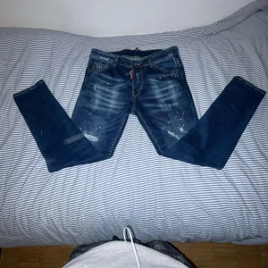 Mörkblå jeans från Dsquared2 - Snygga mörkblå jeans från Dsquared2 med slitna detaljer och en cool tvätt. De har en klassisk femficksdesign och en röd etikett bak. Perfekta för en trendig look! Och självklart kan priset diskuteras!!