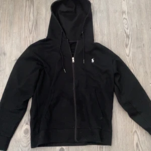 Svart hoodie från Polo Ralph Lauren - Hej, säljer nu denna snygga zip-hoodie från polo ralph lauren då den inte passar mig längre. Tröjan är knappt använd och har inga defekter. Nypris- 2000 Mitt pris- 439