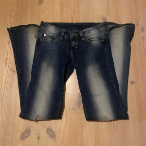 weekday jeans bootcut - Snygga mörkblå jeans med en klassisk bootcut-stil. De har en lätt tvättad look med ljusare partier på låren och knäna. Perfekta för en avslappnad stil.