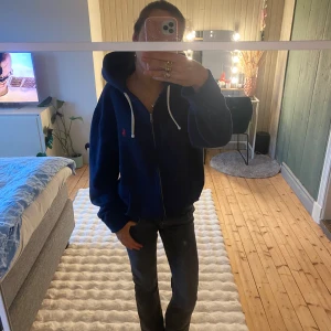 Ralph Lauren - Säljer en snygg mörkblå hoodie från Ralph Lauren med dragkedja och vita snören. Verkligen i nyskick, vilket innebär att den fortfarande är jätte mjuk på insidan. 100% äkta🤗hör av dig vid frågor eller funderingar. Pris går att diskuteras vid snabb och smidig affär🤗