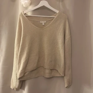 Ljus gul/Beige tröja från H&M - Säljer en mysig ljusgul/ beige tröja från H&M. Tröjan har en v-ringad hals och långa ärmar. Perfekt för en avslappnad stil. Den är tillverkad i ett mjukt material som känns skönt mot huden.