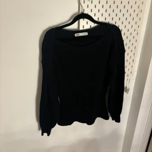 Svart stickad tröja från Zara - Snygg svart stickad tröja från Zara med långa ärmar och ribbade detaljer på axlarna. Perfekt för kyligare dagar och enkel att matcha med olika outfits.