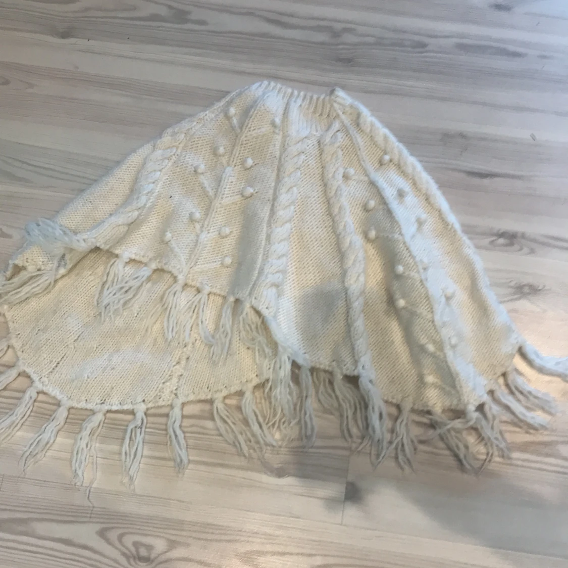 Vit poncho med knoppar på från Kappahl 