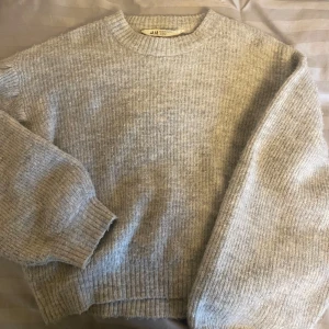 Grå stickad tröja från H&M - Mysig grå stickad tröja från H&M i storlek 146/152. Perfekt för kyliga dagar med sin mjuka och bekväma passform. Tröjan har långa ärmar och en klassisk rund halsringning. Den är lite nopprig(se bild 2) men inget man tänker på:)