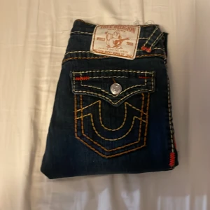 Mörkblå jeans från True Religion - Mörkblå jeans från true religion, har köpt de på plick men de var för korta i benen och det ser ut som att personen jag har köpt de av värkar ha klipt av dem längst ner så innerbenslängden är 65 cm , men förutom att de är klippta i  är de i bra skick. Pris kan diskuteras!
