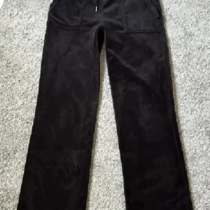 Svarta byxor från Juicy Couture - Snygga svarta byxor från Juicy Couture i mjukt material. De har en bekväm passform med elastisk midja och praktiska fickor med knappar. Perfekta för en avslappnad stil, jag köpte dem här på Plick, och har använt ett par gånger, bilderna är inte mina fört utom den sista, skriv vid fler bilder och pris kan diskuteras💗