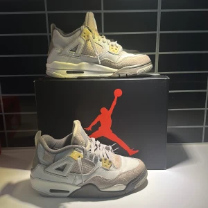 Nike Air Jordan 4 Crafts  - Snygga Nike Air Jordan 4 Crafts  sneakers i en stilren beige och vit färgkombination. Skorna har en klassisk design med snörning och ikoniska detaljer. Perfekta för dig som älskar en sportig och trendig look.