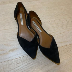 Svarta ballerinaskor med spetsig tå - Eleganta svarta ballerinaskor med spetsig tå och låg klack. Tillverkade i ett mjukt material som ger en bekväm passform.