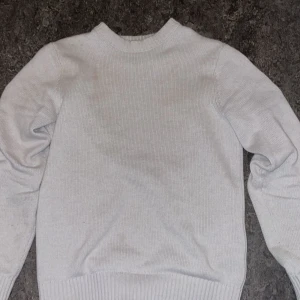 Vit stickad tröja från Dobber - Säljer en stilren vit stickad tröja från Dobber. Tröjan har långa ärmar och ribbstickade muddar vid ärmslut och nederkant. Perfekt för kyligare dagar. Passar bra till allt. 🧥
