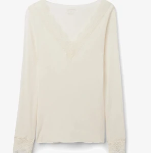 Intimissimi tröja - Elegant vit långärmad topp med v-ringning och spetsdetaljer vid hals och ärmslut. Perfekt för en stilren look.