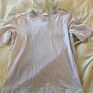 Ljusblå t-shirt från Gina Tricot - Säljer en ljusblå t-shirt från Gina Tricot. Den har en enkel design med korta ärmar och rund hals. Perfekt för en avslappnad stil. Passar bra till jeans eller shorts.