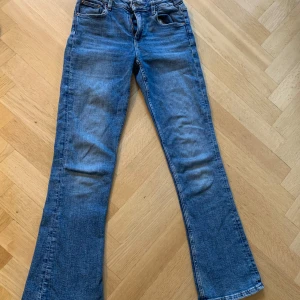 Blåa bootcut jeans  - Blåa midwaist bootcut jeans säljes i storlek 164 för 100 kr! De har en liten rosa fläck på baksidan (är osäker om den går att få bort)! Köparen betalar frakten!