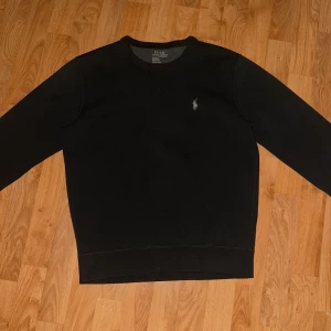Ralph Lauren Sweatshirt - Säljer en stilren svart tröja från polo ralph Laurent på grund av att den inte passar. ”65cm lång, 50cm bredd”.