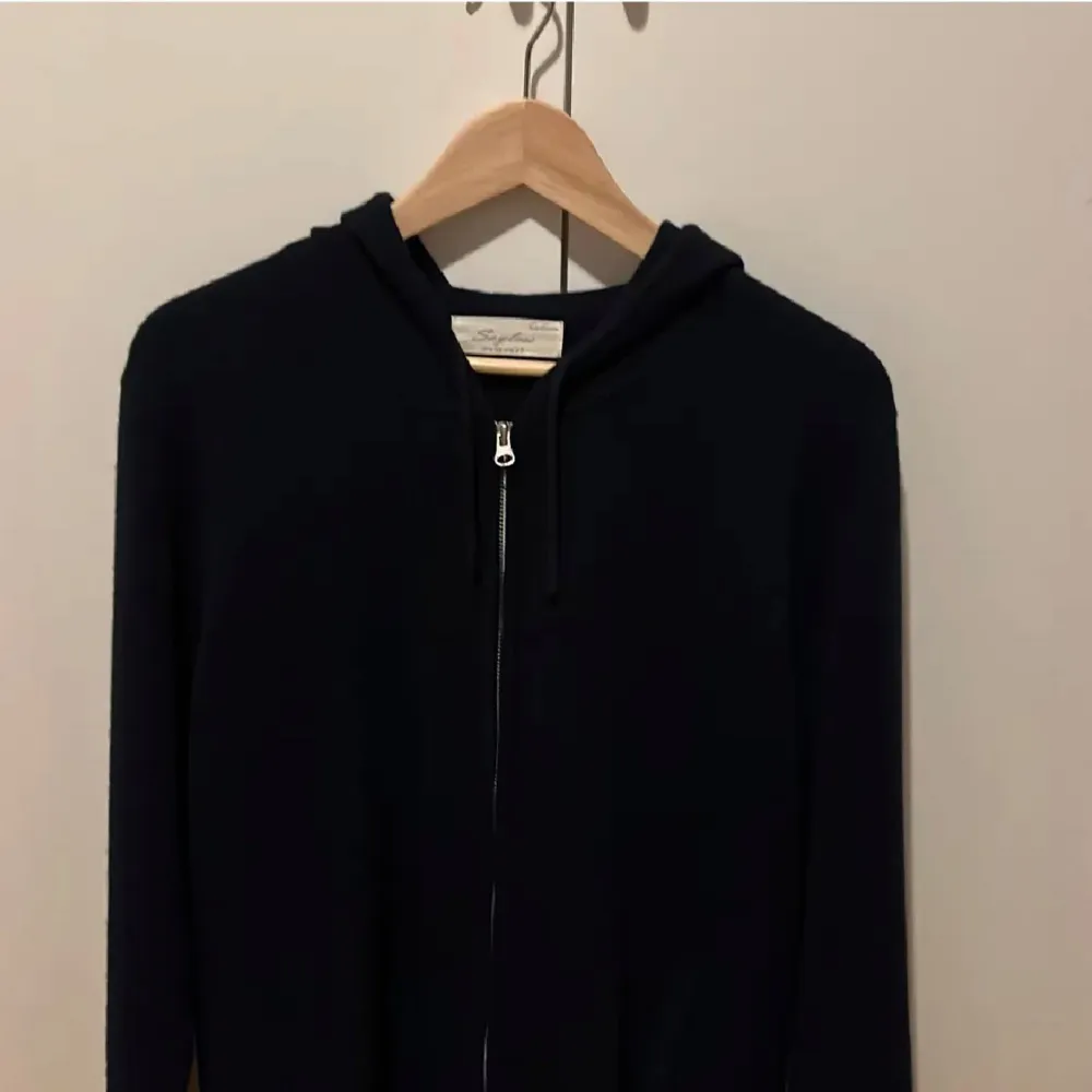 Snygg marinblå hoodie från sayless med dragkedja framtill och huva. Perfekt för en avslappnad stil och enkel att matcha med andra plagg. Ett måste i garderoben för alla som gillar bekväma kläder. Nyskick . Neuletakit & Villapaidat.