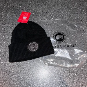 Svart mössa  - Snygg svart mössa  med broderad logotyp framtill. Tillverkad i ett mjukt och värmande material, perfekt för kyliga dagar eller ha extra stil som ger dig fresh look. Mössan har en klassisk ribbad design och en uppvikt kant för extra stil och komfort. Först till kvar! Om ni undrar något bara hör av er!