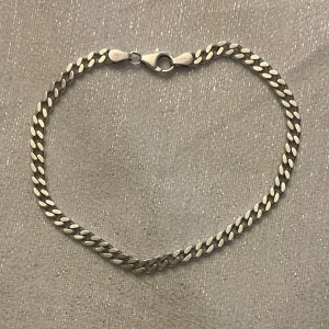 Silver kedja- armband  - Elegant silver kedja med klassisk kedjedesign. Perfekt för att lägga till en stilren touch till din outfit. Armbandet har en säker låsning och en tidlös look.