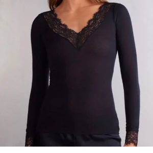 Intimissimi tröja - KÖP ENDAS MED SWISH!      legant svart topp med lång ärm och v-ringning dekorerad med spets. Perfekt för en stilren look.