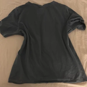 Blå t-shirt från Gina Tricot - Säljer en blåt-shirt från Gina Tricot. Den har en enkel design med korta ärmar och rund halsringning. Perfekt för en avslappnad stil.