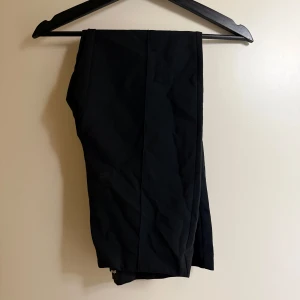 Svarta byxor från Gina Tricot - Snygga svarta byxor från GinaTricot i en klassisk stil. Perfekta för en stilren look med en bekväm passform. Byxorna har en enkel design som gör dem lätta att matcha med olika toppar.