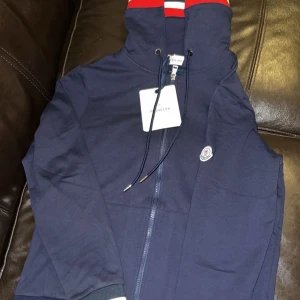 Moncler zip hoodie - Säljer min moncler tröja, fick den i julklapp av min farbror men den var lite för liten. Tröjan är aldrig använd alltså i nyskick. Riktigt fin och passar även till allt. 