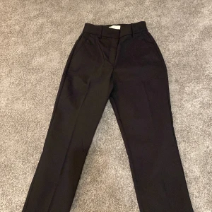Svarta kostymbyxor - Snygga svarta kostymbyxor i klassisk stil. De har en hög midja och raka ben, vilket ger en elegant look. Perfekta för en stilren outfit. Inga defekter, använd knappt.