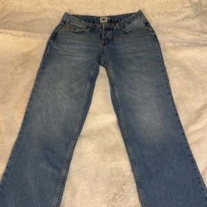 Blåa jeans  - Snygga blåa jeans som aldrig används med klassisk femficksdesign och knappgylf. De har en rak passform och är tillverkade i slitstarkt denim. Mid/high waist. Stl M, längd 110cm och 40cm bred från ficka till ficka. 