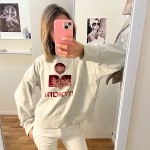 Grå sweatshirt med röd logga - super snygg isabel marant tröja, den är i användt skick!! ❤️ är i storlek 40 men passar mig som brukar ha xs/s!!
