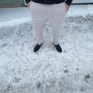 byxor från Zara - Snygga byxor från Zara med en avslappnad passform. Byxorna har en midwaist design och är perfekta för en stilren look. De har fickor både fram och bak, vilket ger en praktisk touch.