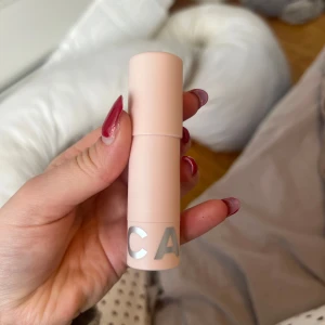 Blurring Stick från Caia  - Säljer en Blurring Stick från Caia  i en ljusrosa förpackning. Denna primer är designad för att sudda ut porer och ge en jämnare hudton. Perfekt för att skapa en slät bas innan sminkapplicering.