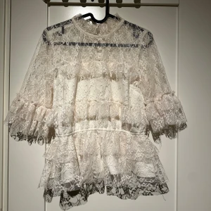 Vit spetsblus med volanger - Vit spetsblus från bubbleroom i stl 36. Den är i fint skick.