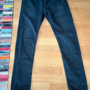 Levis jeans  - Snygga svarta jeansbyxor med en slim passform. De har en klassisk design med fem fickor och en dragkedja. Perfekta för en stilren look.                             Skriv gärna ditt bud då priset kan sänkas!!!