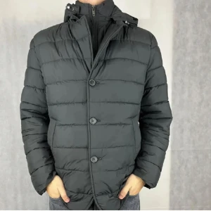 John Henric Jacka - Snygg grå pufferjacka med både dragkedja och knappar framtill från John Henric. Jättefint skick.  Jackan har en hög krage och en avtagbar huva, perfekt för kyliga dagar. Den quiltade designen ger extra värme och stil. Säljer den då den tyvärr var för stor för mig. 