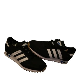 Svarta Adidas LA Trainer sneakers (Helt nya) - ADIDAS LA TRAIENERS i storlek 39 1/3. Säljer för 799 inte hugget i sten. Ny pris på dessa är runt 1299. Skorna är i nyskick och inte använda.Hör av vid frågor och funderingar. 