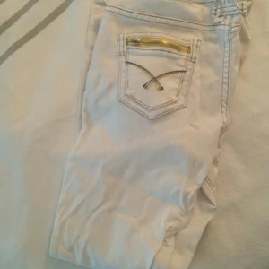 Vita byxor med dragkedjedetaljer - Snygga vita utsvängda/raka jeans! Köpta second hand så osäker på hur mycket dom använts! Inga fläckar eller defekter                              Midjeomkrets: 78 cm  totalt längd: 102 cm  ben bredd: 23 cm