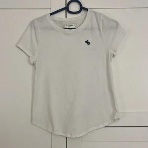 Vit t-shirt från Abercrombie Kids - Säljer en klassisk vit t-shirt från Abercrombie Kids. Väldigt bra skick, strl 11/12, stor i storleken!!💗