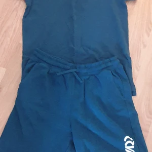 Blå shorts med snörning - Snygga blå shorts från Warp med bekväm snörning i midjan. Perfekta för en avslappnad stil. Puke tröja i samma set.