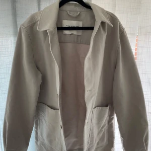 Grå kavaj från These Glory Days - Säljer en stilren grå jacka från These Glory Days. Jackan har långa ärmar och knappar framtill. Perfekt för en minimalistisk look.