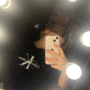 Svart hoodie från Calvin Klein Jeans - Säljer en svart hoodie från Calvin Klein Jeans med CK-logotypen tryckt på framsidan.  Hoodien har en huva och är tillverkad i mjukt material för extra komfort. Älskar denna men andvändes för sällan och nu för liten. Den är st 14 men ganska liten i st. Nypris 899