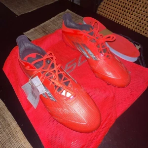 Röda fotbollsskor från Adidas - Säljer ett par röda Adidas F50 elite  fotbollsskor med snörning och en lätt syntetisk ovandel. Skorna har en slimmad design och är perfekta för snabba rörelser på planen. Säljer de eftersom de var för stora. Testat en gång på träning. Nyskick. Pris kan diskuteras vid snabb affär!!!!!!!!