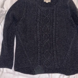 Grå stickad tröja från Denim & Supply Ralph Lauren - Säljer en snygg grå stickad tröja från Denim & Supply Ralph Lauren. Tröjan har ett fint flätmönster framtill och är perfekt för kyligare dagar. Den har långa ärmar och en rund halsringning.