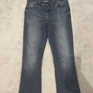 Grå jeans med bootcut - Snygga grå jeans med bootcut-stil. De har en klassisk femficksdesign och en lätt tvättad look. Perfekta för en avslappnad stil.