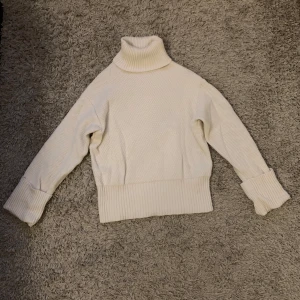 Vit stickad polotröja - Vit stickad polotröja med hög krage och långa ärmar.