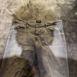Grå jeans från Jack & Jones - Snygga grå jeans från Jack & Jones, modell Glenn. De har en klassisk femficksdesign med knapp och dragkedja. Perfekta för en stilren look. Köpte dom för 899