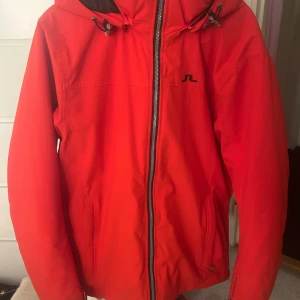 Röd skidjacka från J.Lindeberg - Snygg röd jacka från J.Lindeberg med dragkedja och justerbar huva. Nypris är ca 3500-4000, finns några få defekter men som inte är synliga, dessa finns på bild 4 och 5. Kom gärna med prisförslag om du inte tycker att priset är rimligt 💗(Använd fåtal gånger)