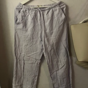 Ljuslila linnebyxor från Gina Tricot - Säljer ett par ljusgrå byxor från Gina Tricot i storlek S. Byxorna har en avslappnad passform med resår i midjan
