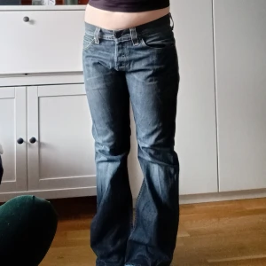Levis Bootcut jeans - Snygga blå Levis jeans med bootcut-stil. De har en klassisk femficksdesign och låg midja. En gnutta slitna i grenen men i helhet bra skick. Modell 512 Bootcut W34 L32🩷