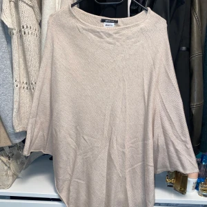 beige poncho - beige poncho från ginatricot som väl använts, men som fortfarande går att bära!