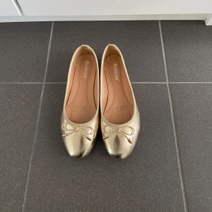 Guldiga ballerinaskor - Så snygga ballerinaskor! Använda en gång då jag inte haft något tillfälle att ha dem! Storlek 38 men passar mig som har 37 vanligtvis. Jättebekväma och mjuka🥰Inga defekter. 